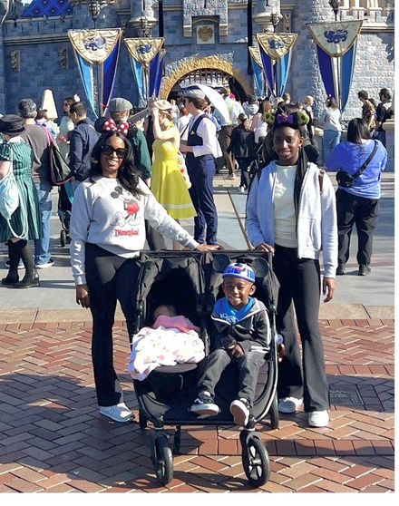 Daniella with her children in front of Cinderella Castle.