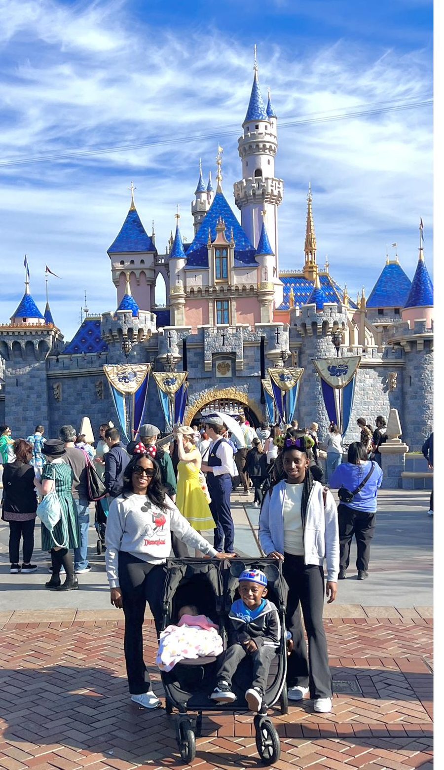 Daniella with her three children in front of Cinderella Castle.